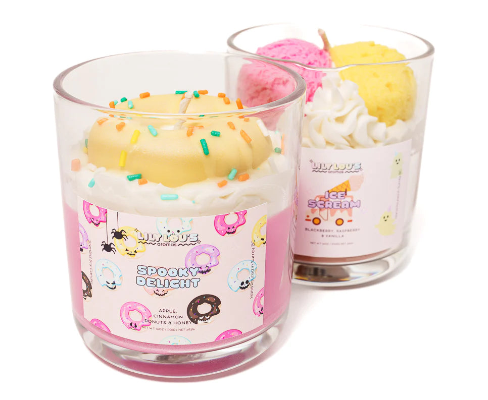 Two glass jar candles with colorful wax and labels featuring donuts