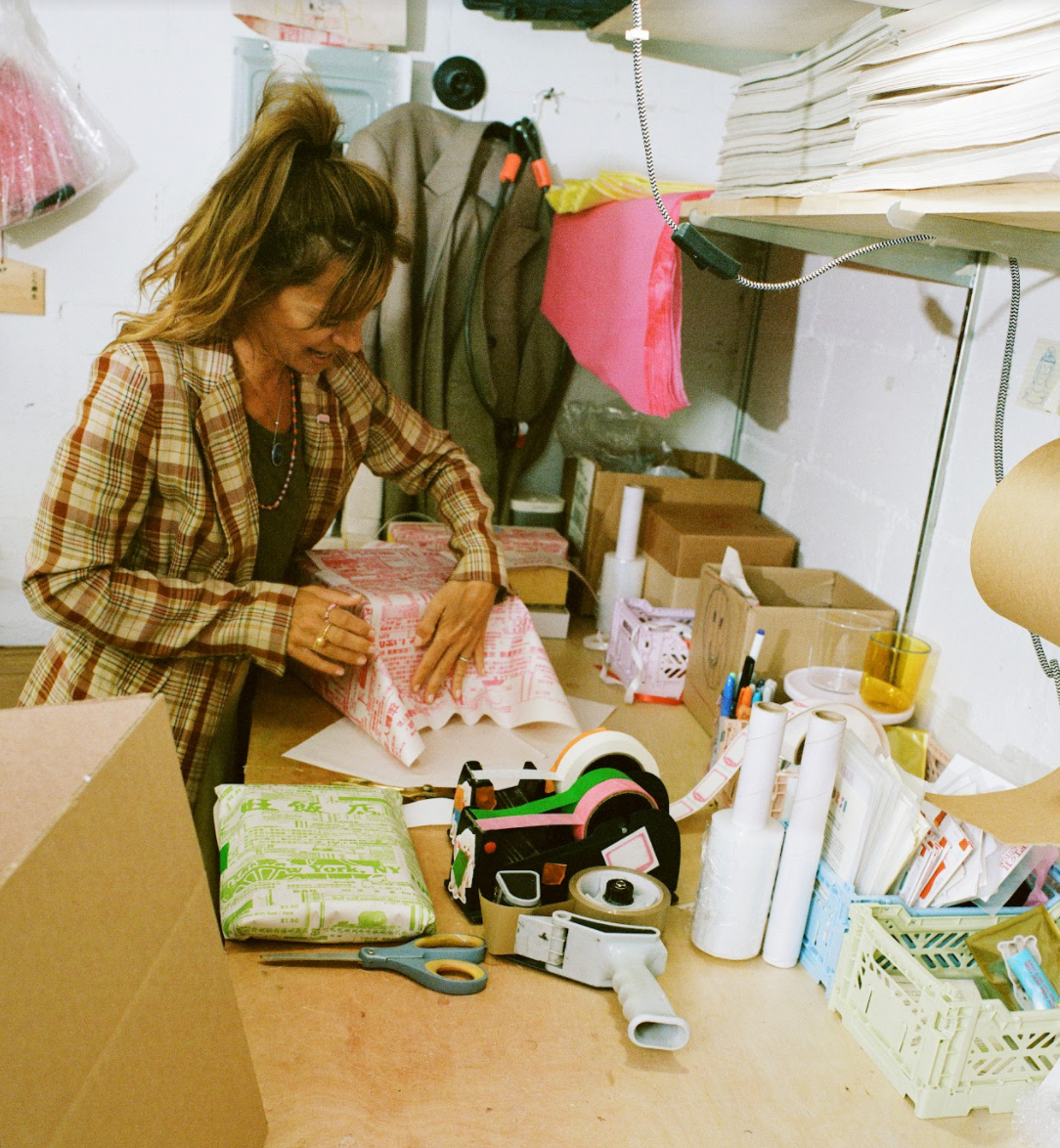 Coming Soon founder wrapping a parcel in a workspace