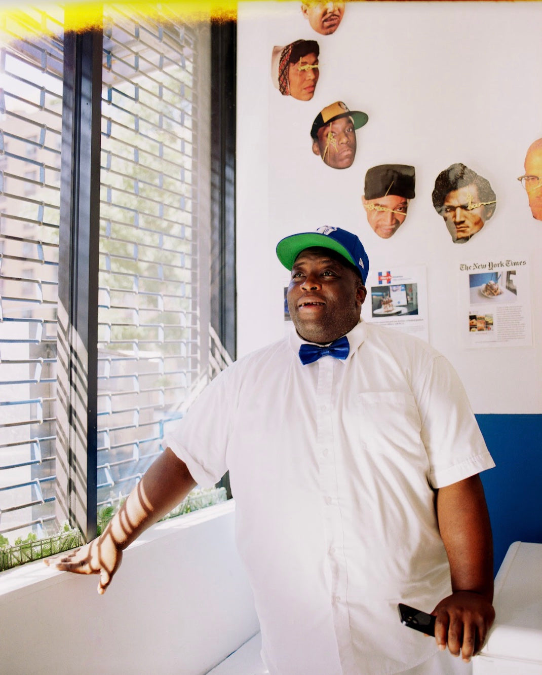 Mikey Likes It Ice Cream founder standing in shop with a white button down and blue snapback