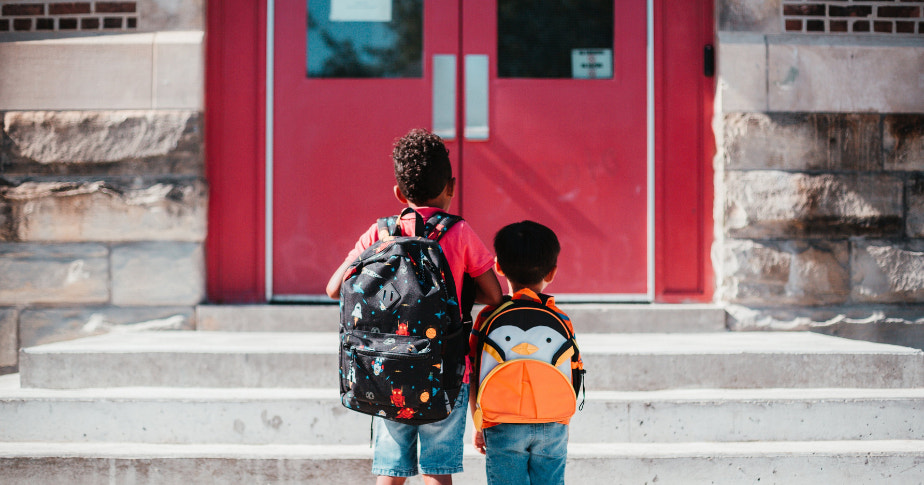 两名学生背着书包回学校。