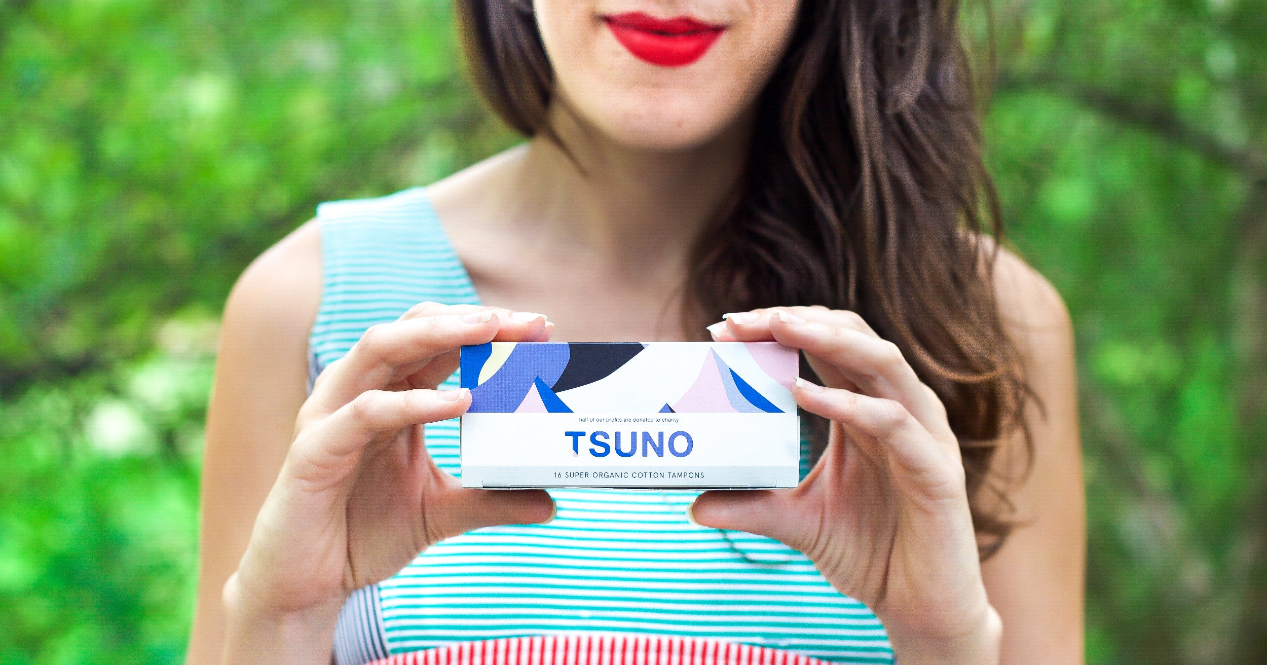 Crop of a woman holding a box of tampons that reads "Tsuno"