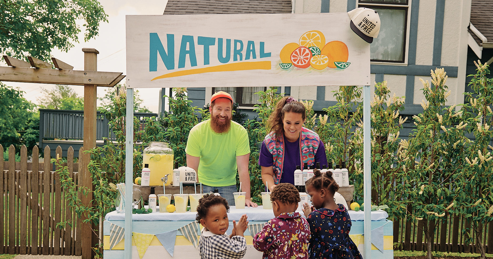 The founders of United & Free serve lemonade to children at a roadside stand