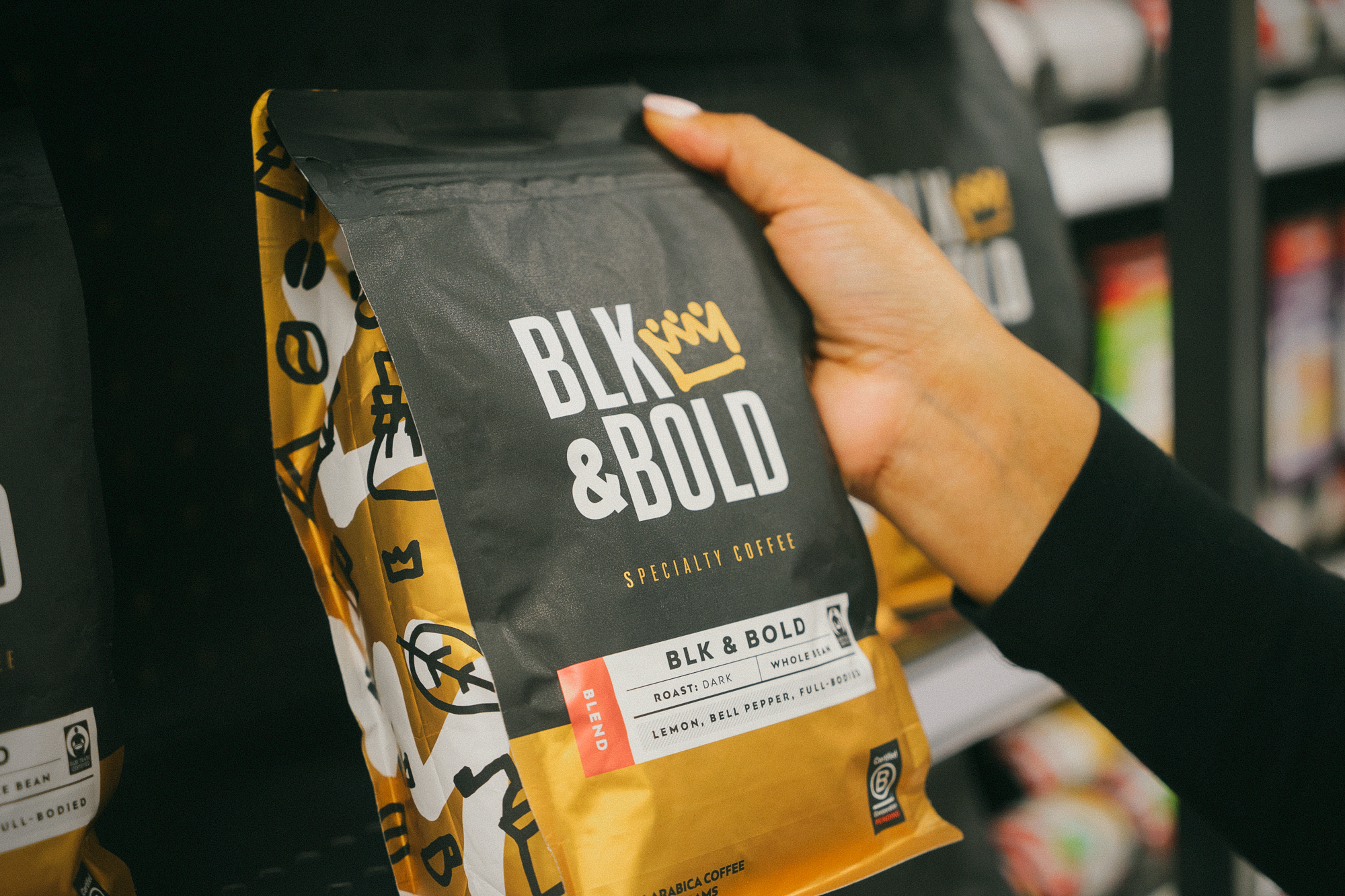 A bag of BLK & Bold Coffee backdropped by some shelves in a retail store. 