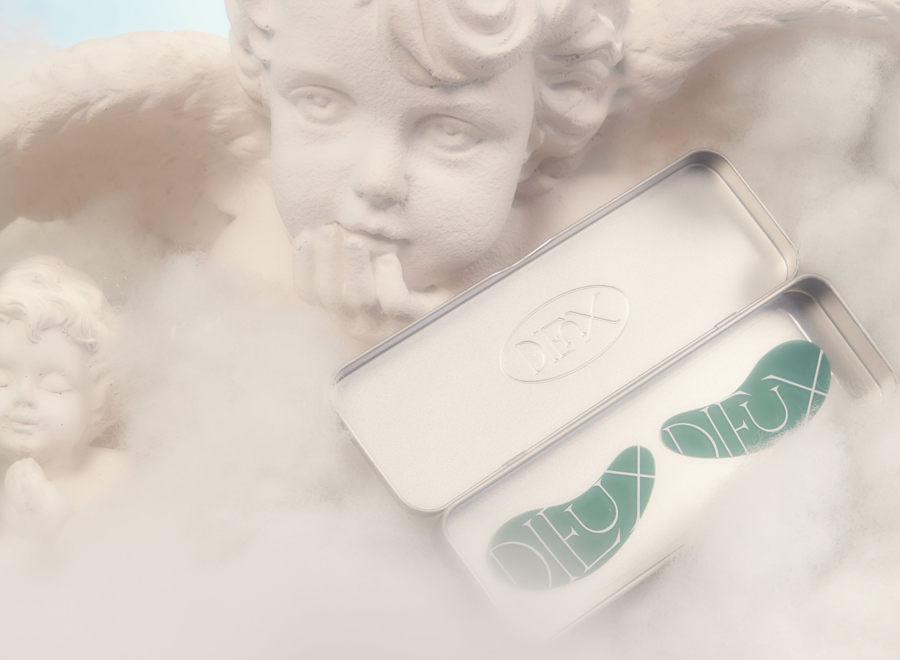 One of Dieux Skin’s best selling products, the Forever Eye Mask floating in the clouds with a large and small angel behind it.