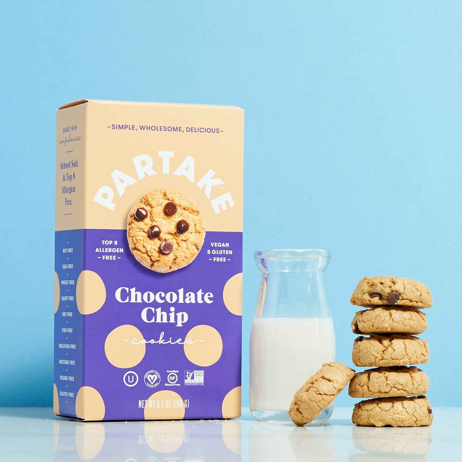 A box of Chocolate Chip cookies by Partake Foods along with a glass of milk and a stack of cookies displayed.