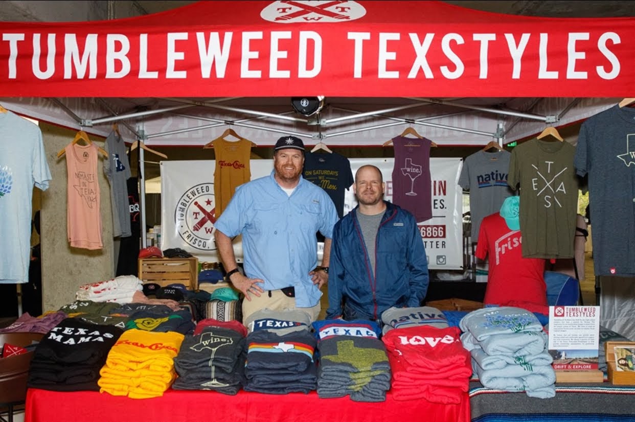 Jeb Matulich and Brian Wysong standing within a Tumbleweed Texstyles booth for a pop-up event promoting the brand. 