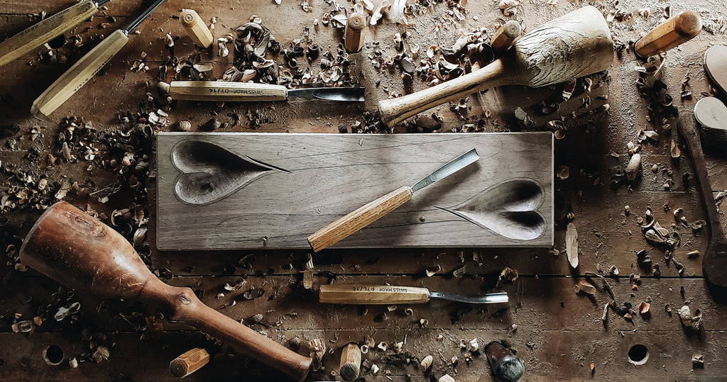 工作台的照片与雕刻工具和心形雕刻的木材