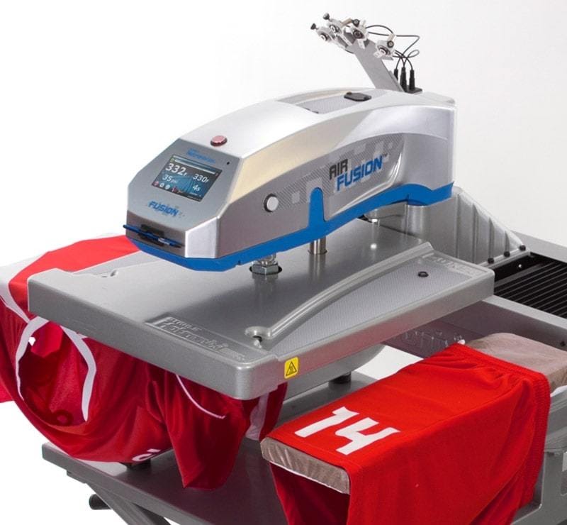 Eine silberne Heißpressmaschine überträgt ein Design auf rote T-Shirts für ein online T-Shirt-Business
