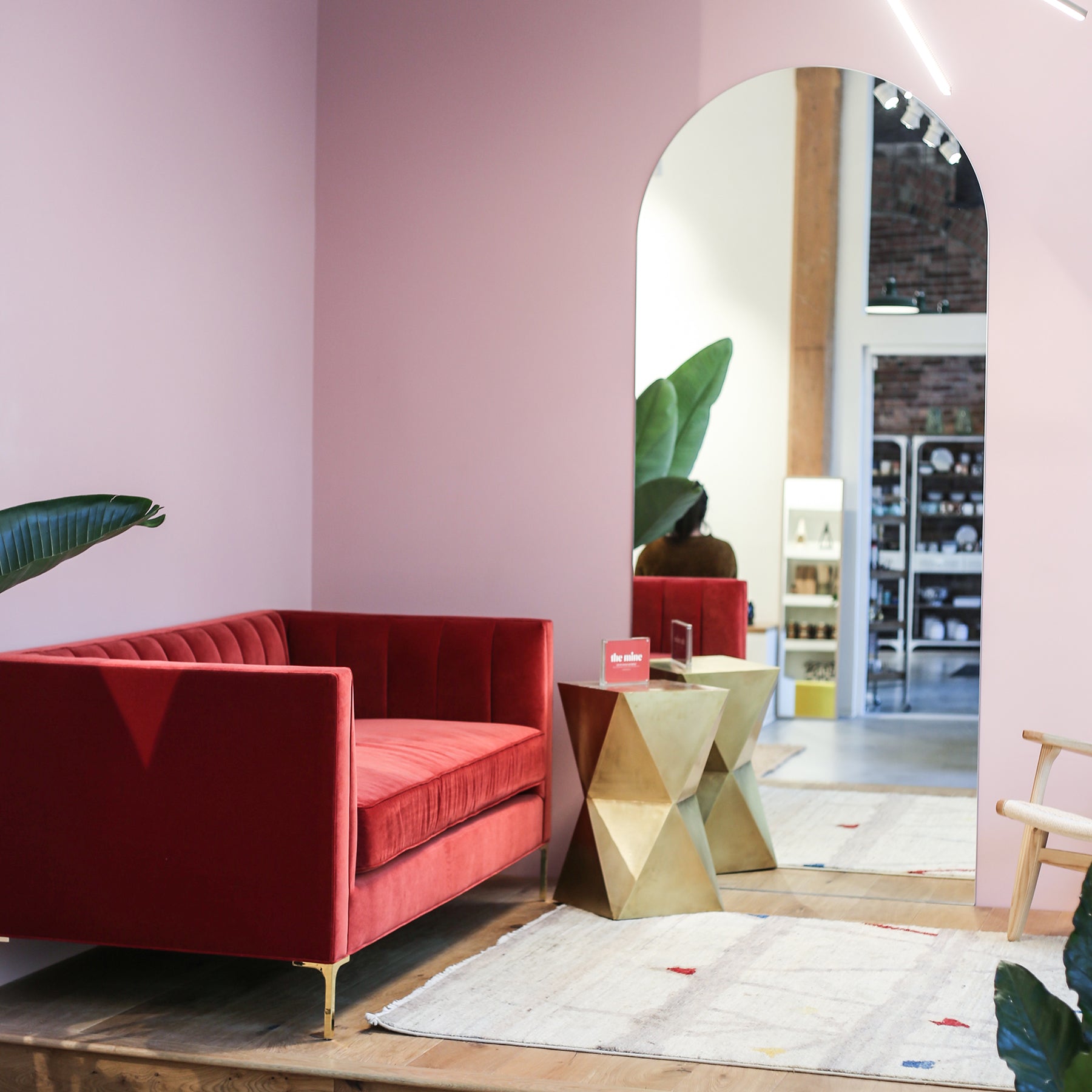 Interior of a store with pink walls and a red couch