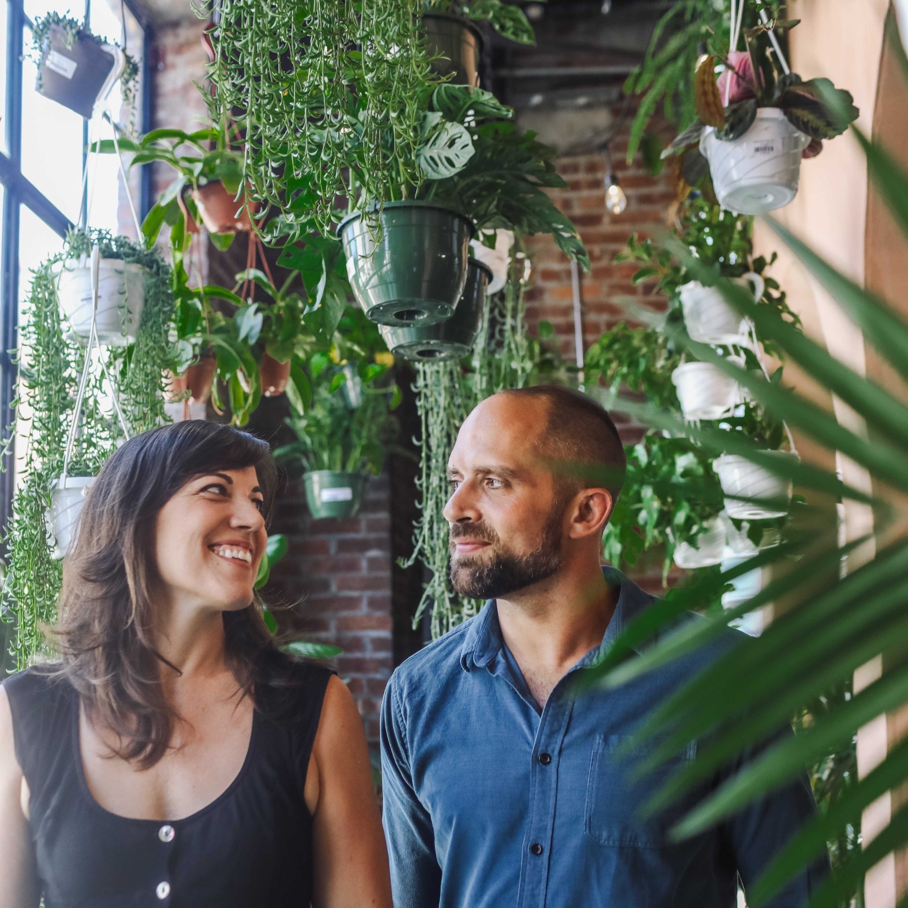 Man and woman standing side-by-side smiling at one another