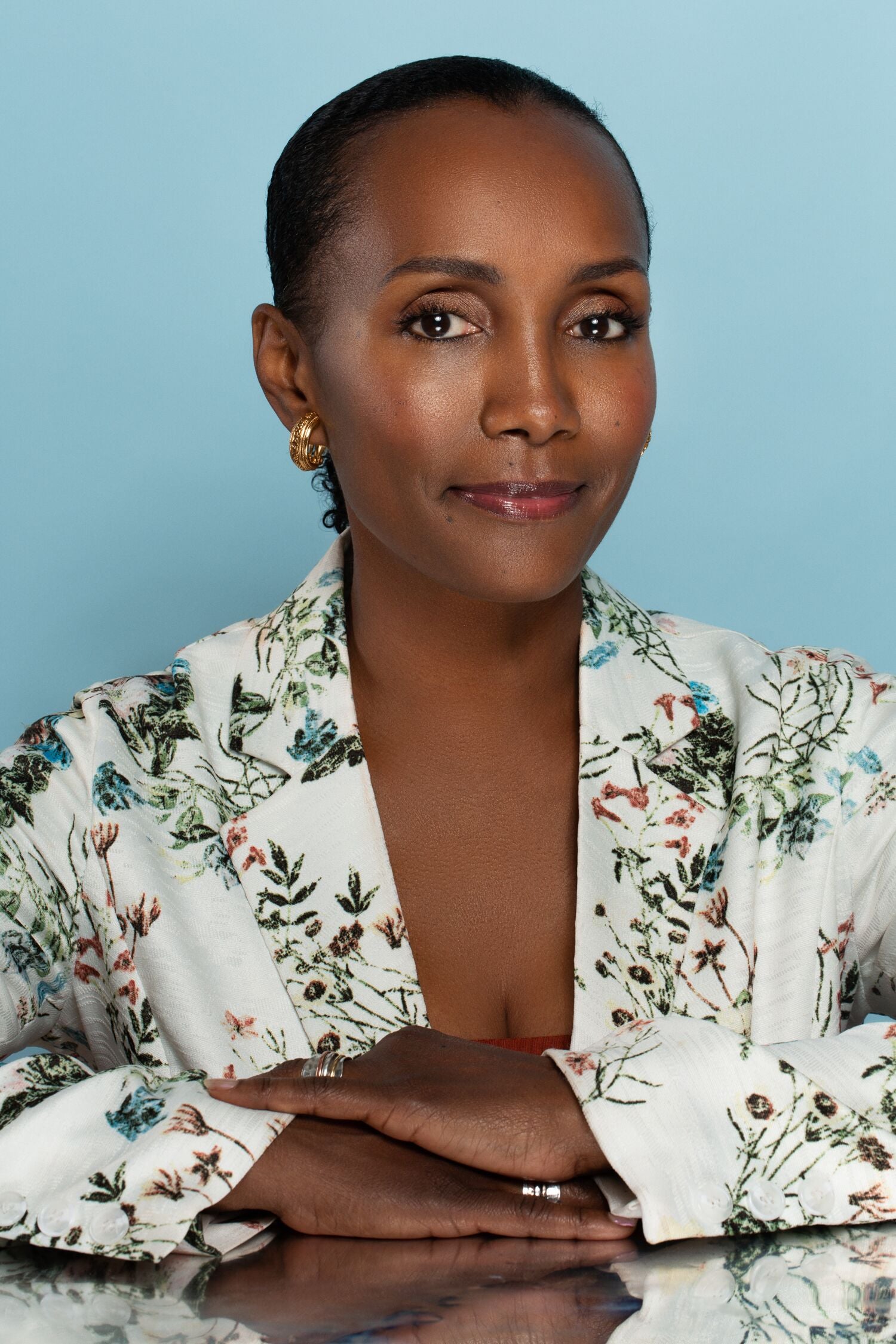 Unsun Cosmetics founder Katonya Breaux smiles at the camera, with her hands folded one on top of the other.  