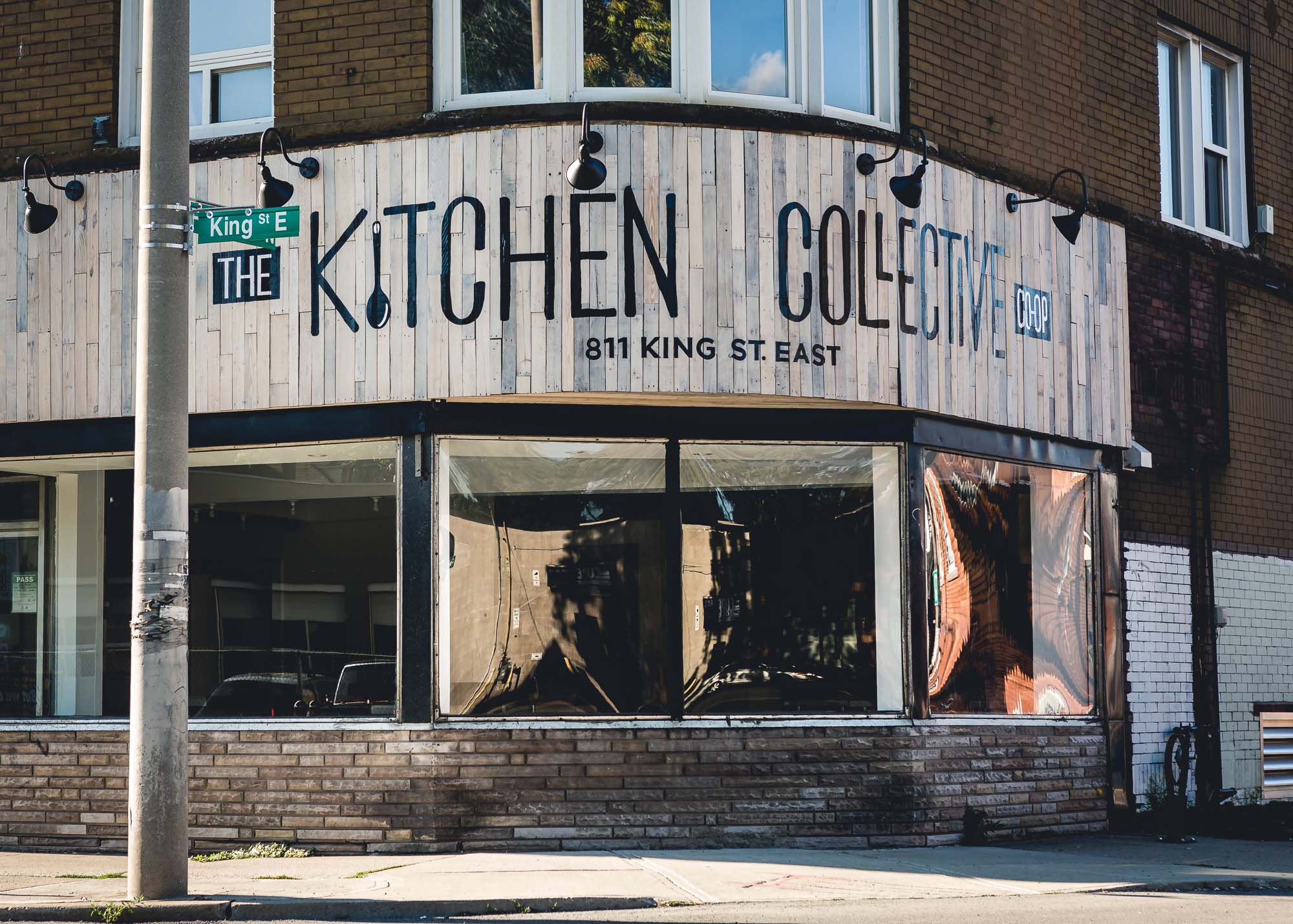 Una vetrina all'angolo di un incrocio con l'insegna Kitchen Collective