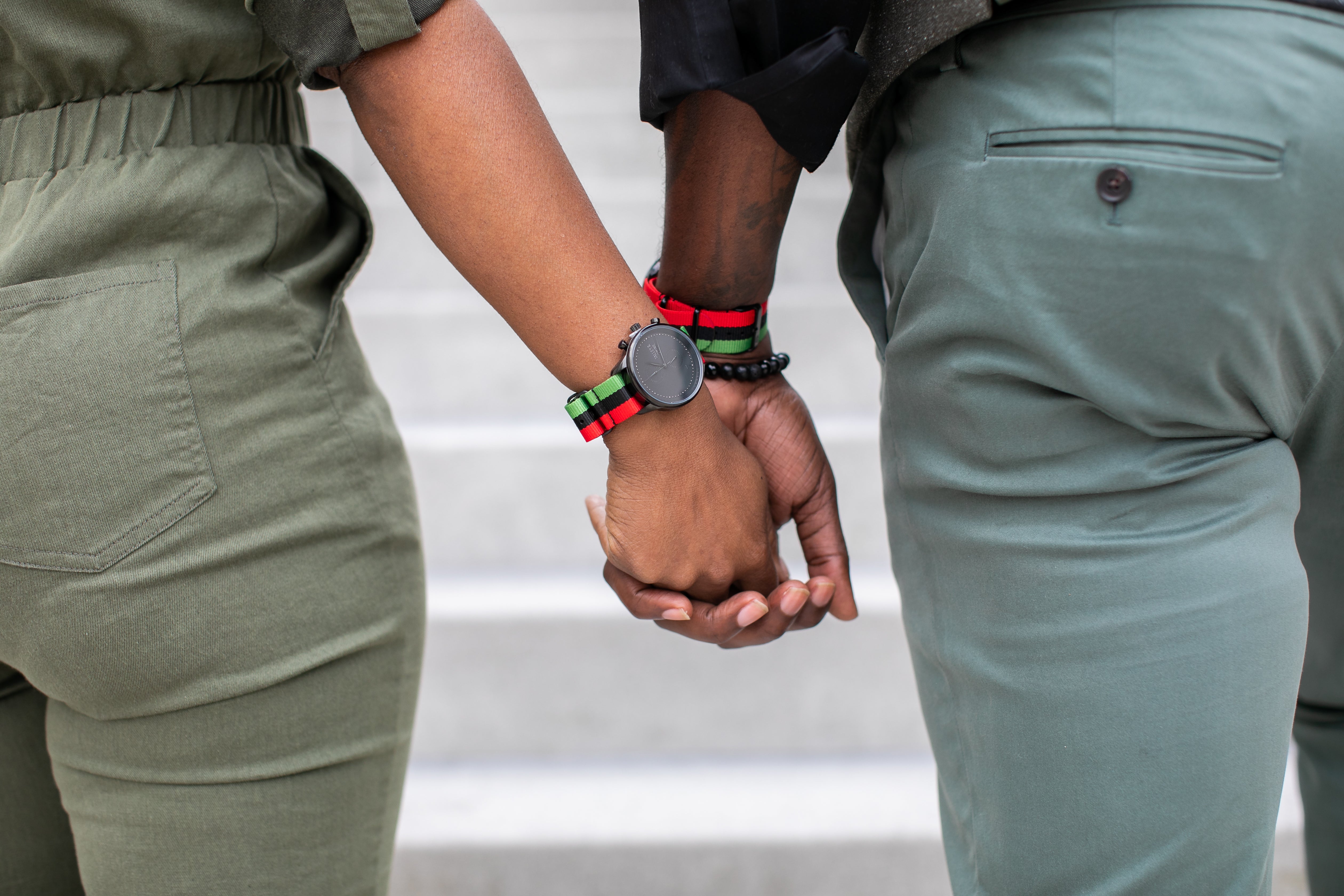 A pair of models in green attire while wearing watches from Talley & Twine. 