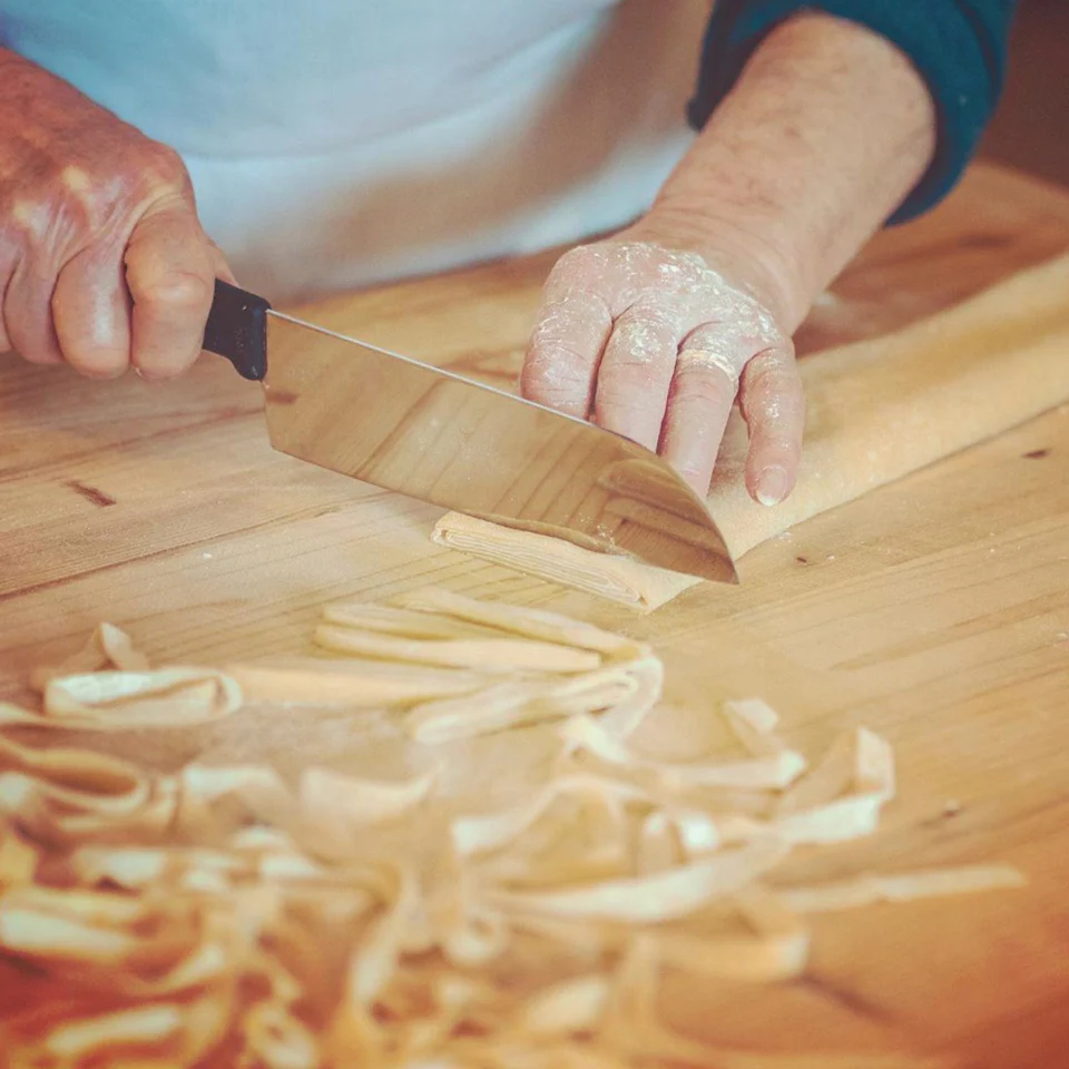 Primo piano di una donna che prepara la pasta fresca fatta in casa