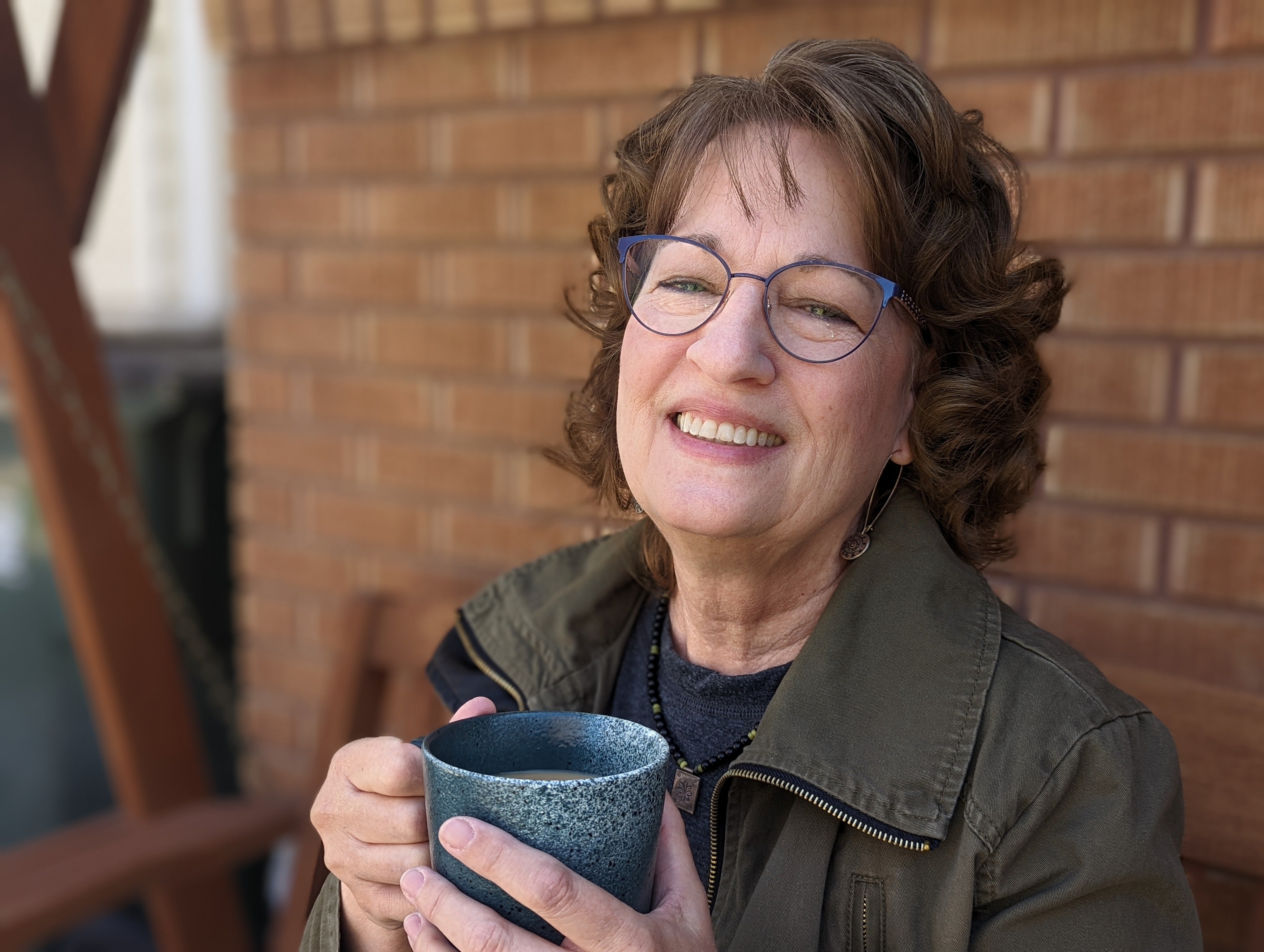 Portrait of Trisha Trout drinking coffee on a porch