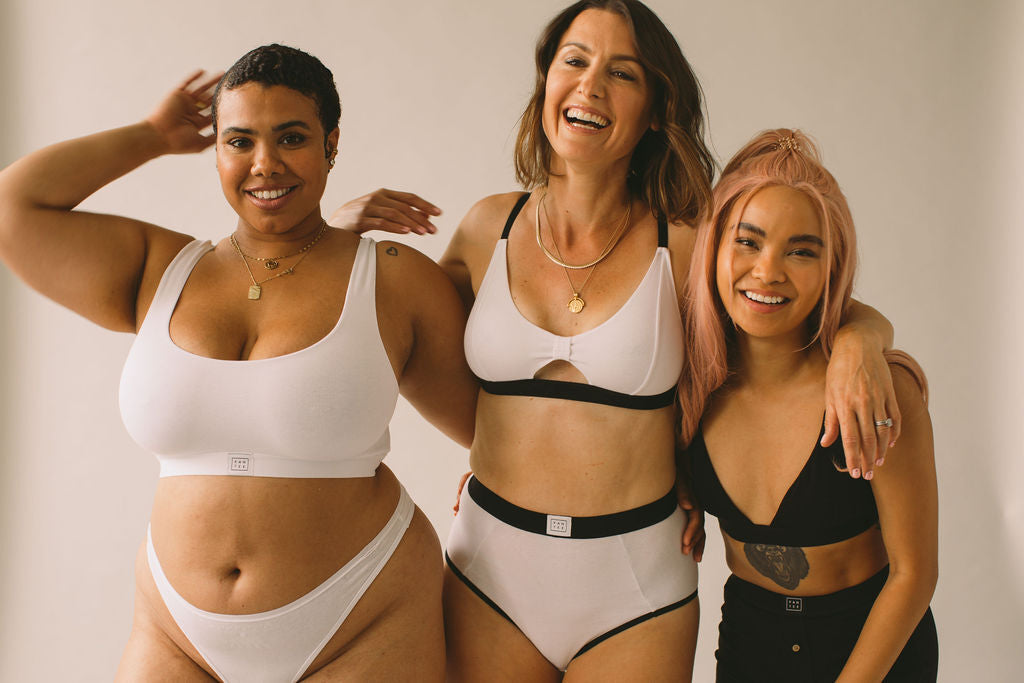 Three models laughing with their arms around each other wearing Pantee sets