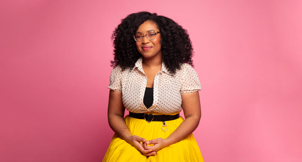 Portrait of the founder of Healthy Roots Dolls against a pink background