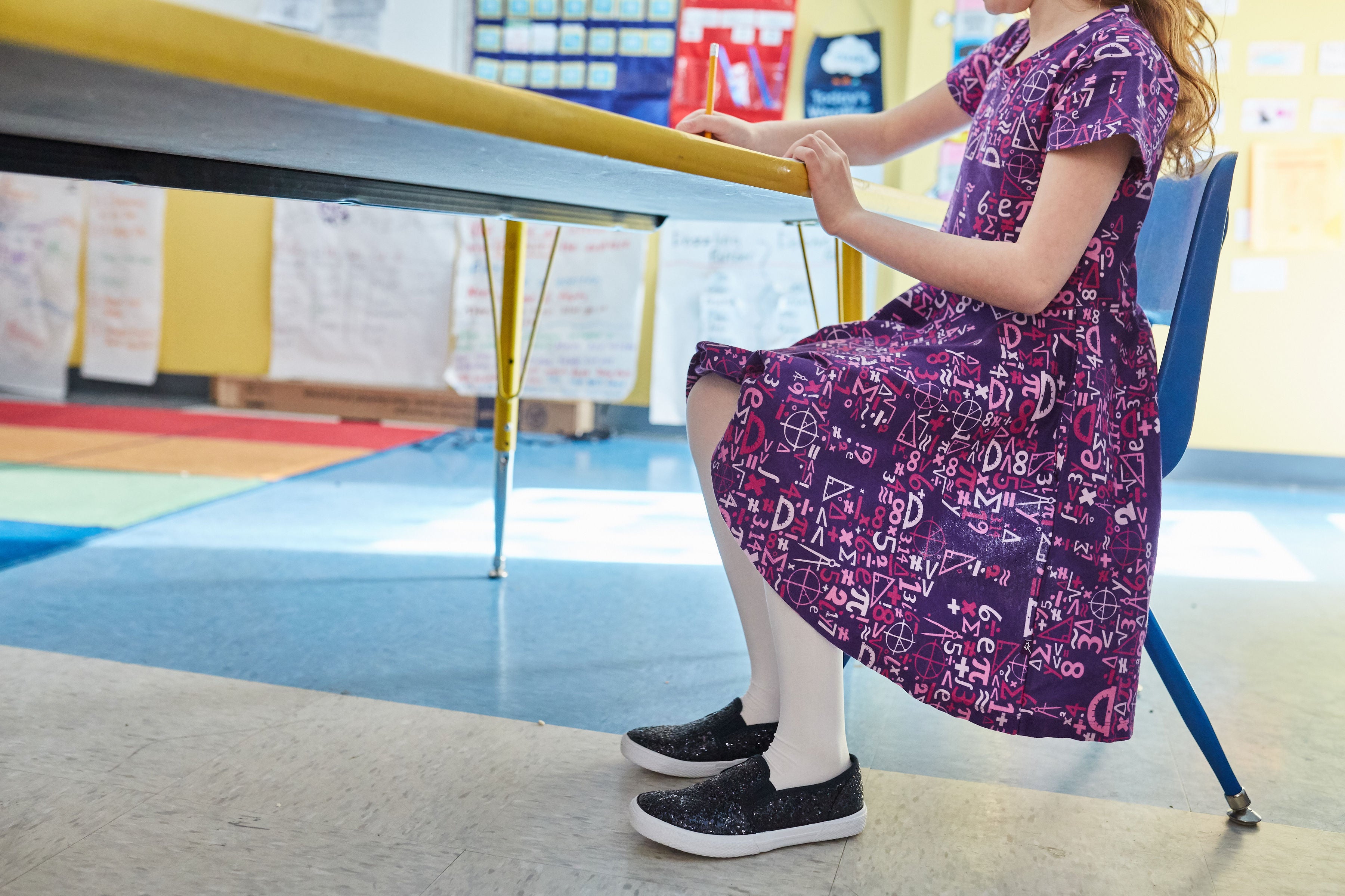 Girl models dress with math symbols.