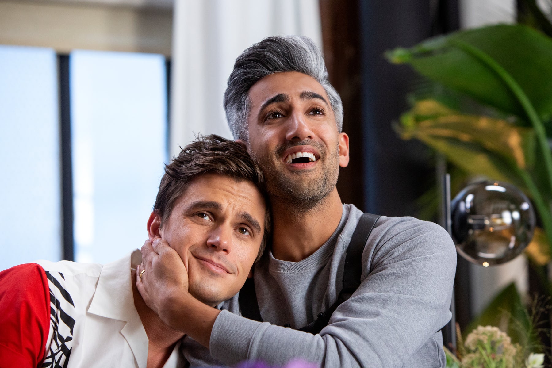 Tan hugs Antoni around the neck in an episode of Queer Eye.