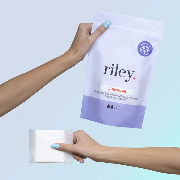 Two hands holding up Riley sanitary pads