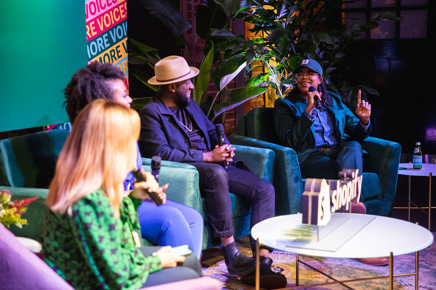 Panelists sit on a stage at AfroTech 2019 listening as Jannah Hardy speaks into a microphone.