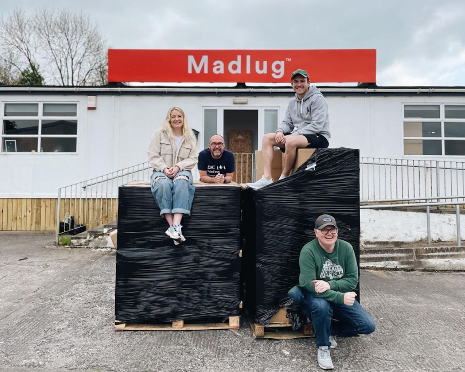 Dave Linton 和他的团队成员在北爱尔兰 Madlug 办公室外与新完成的订单货物合影。