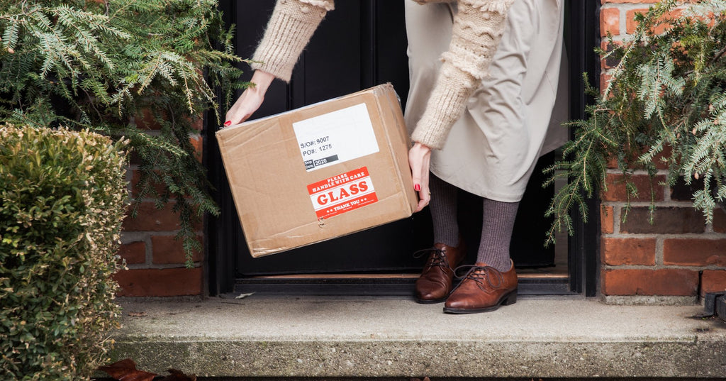 A women picking up a package from her doorstep