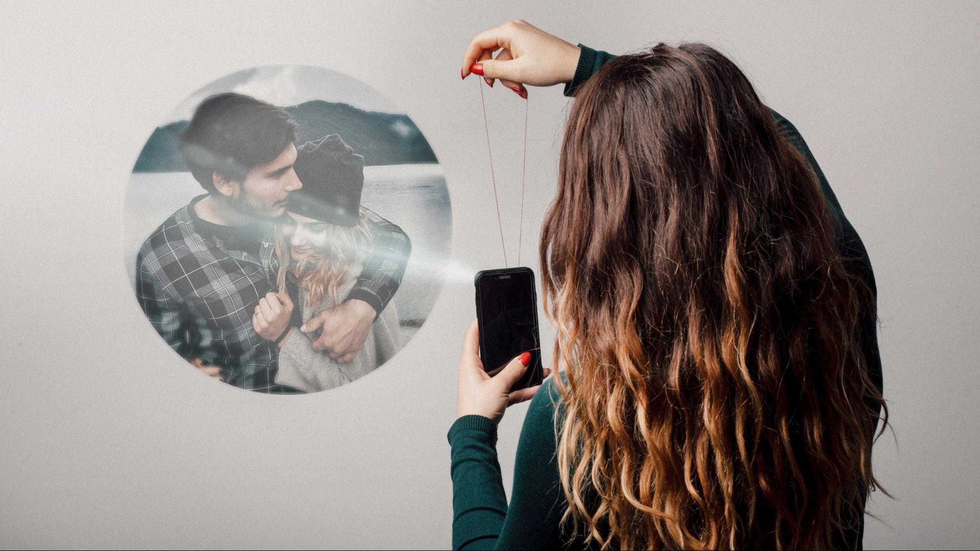 A model shins a light through a pendent from Revival Jewelry that projects a hidden image. 