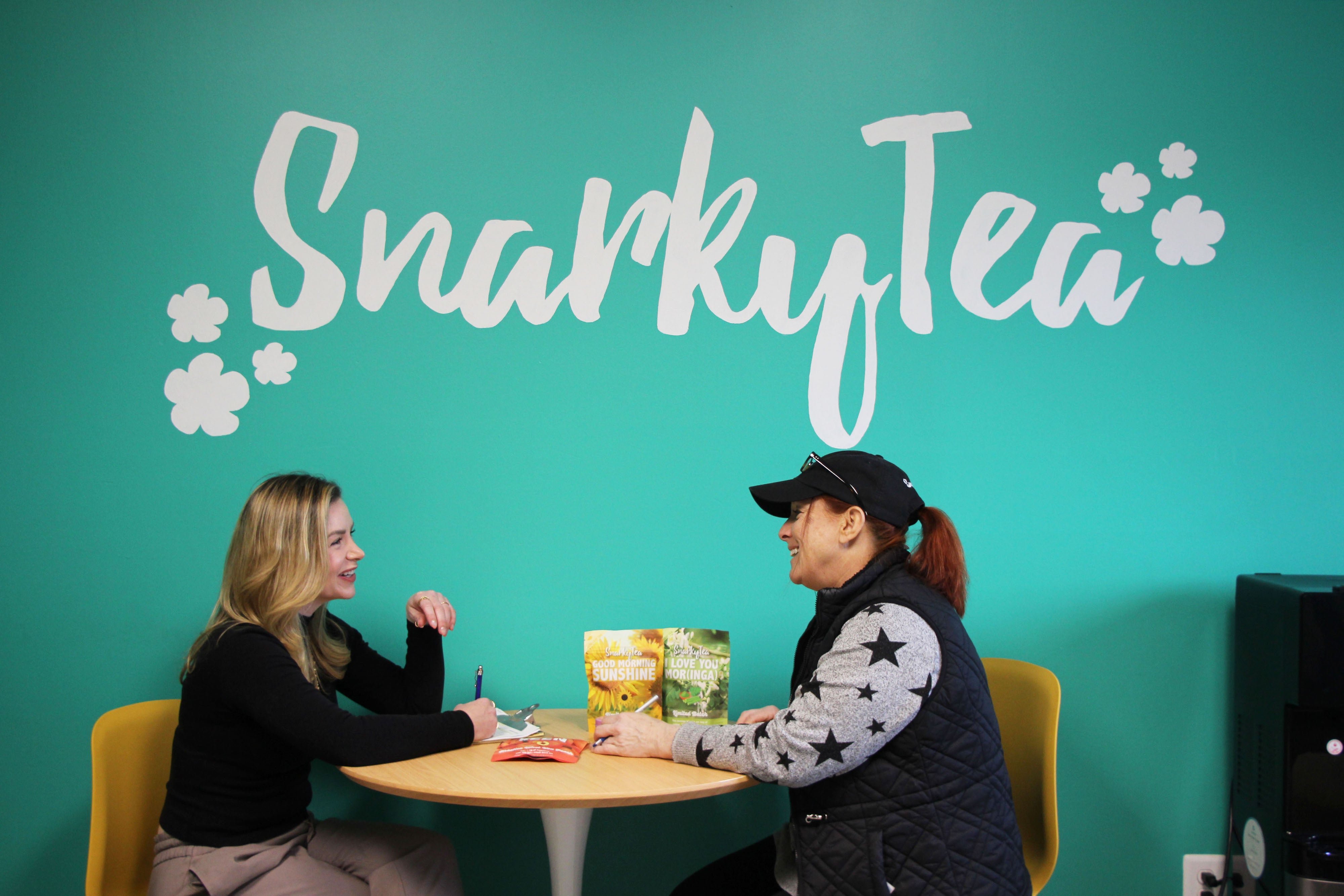Jenni-Lyn Williams, Snarky Tea's Founder and CEO, talking to an employee at the company's fulfillment center