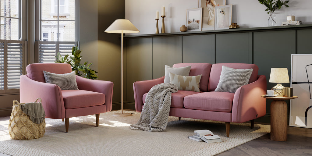 A pink armchair and couch in a living room