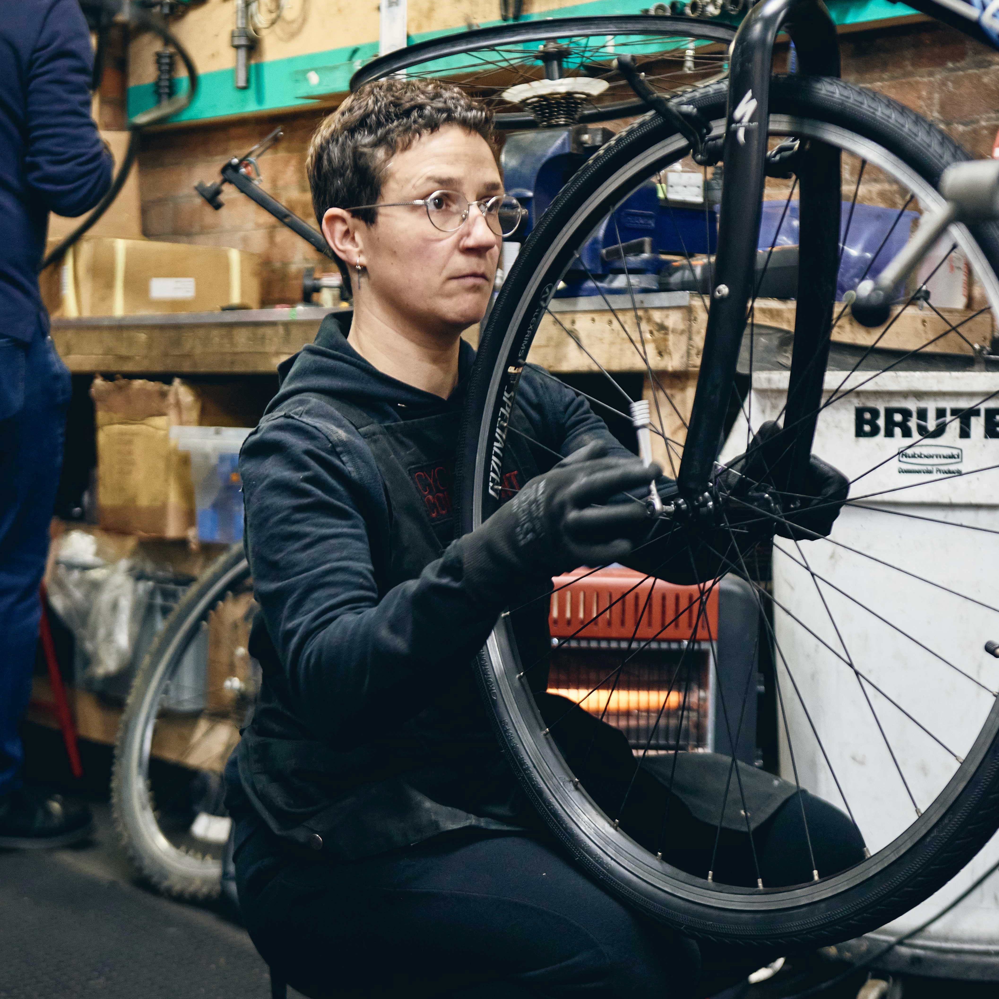 A mechanic fixing up a bike in The Bike Project’s workshop. 