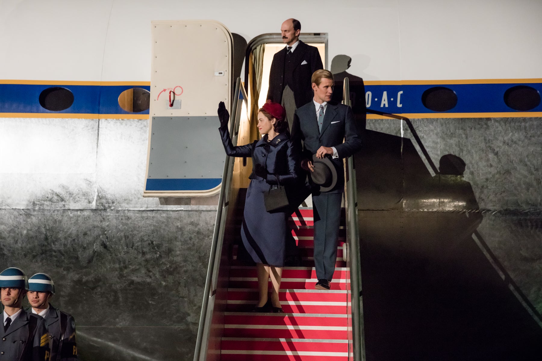 Queen Elizabeth and Prince Philip walk down the steps of their plane