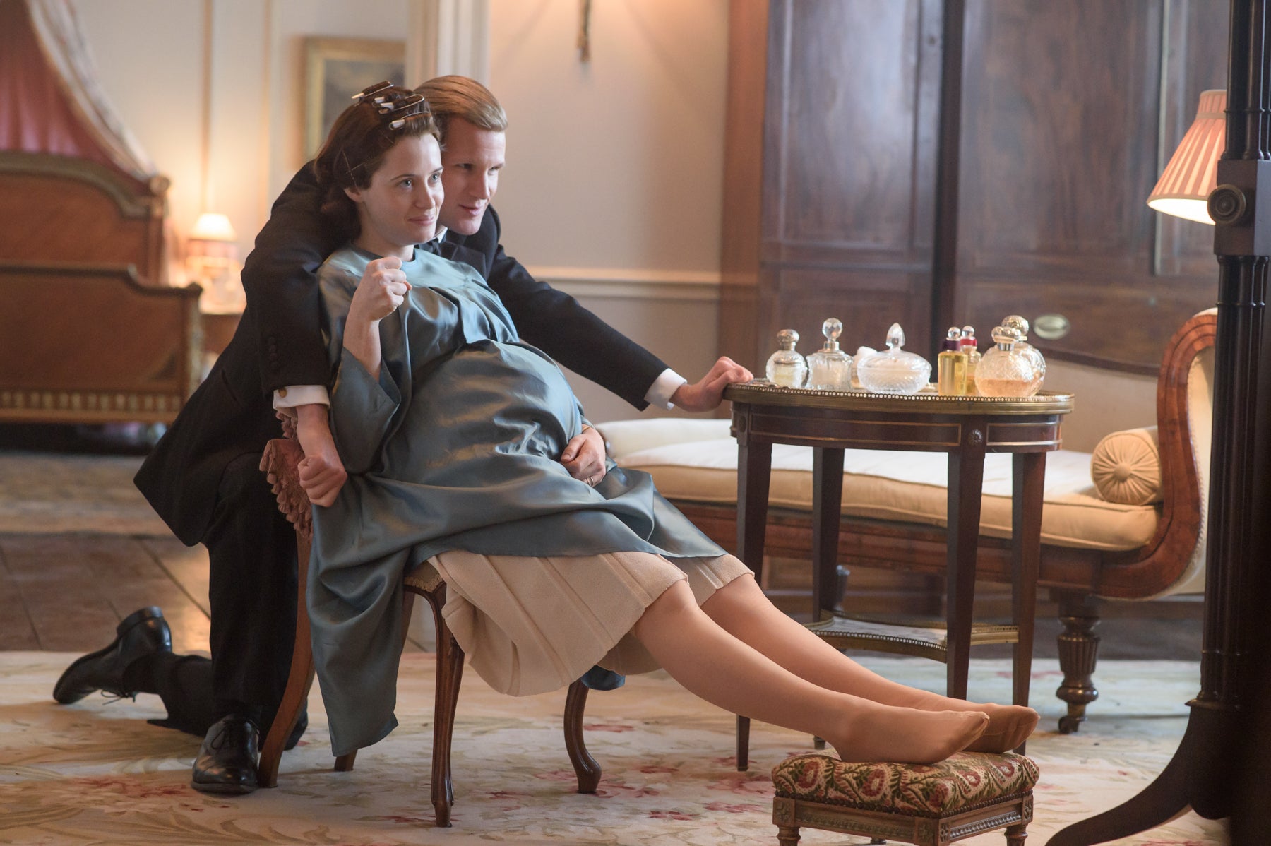 Pregnant Queen Elizabeth and Prince Philip joke around in front of the mirror, while she has her feet up on a footstool