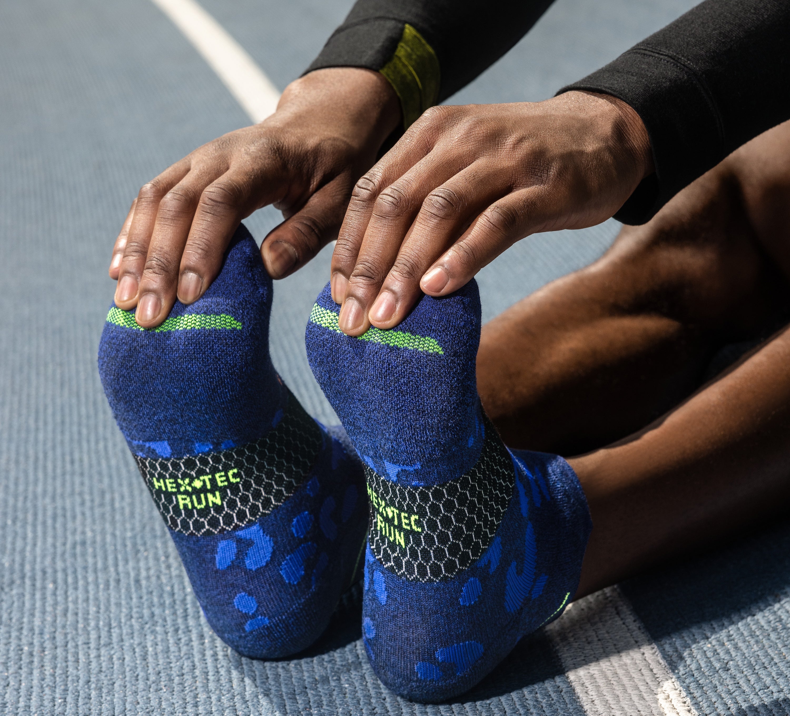 a model stretching and touching his toes in a pair of bombas socks.