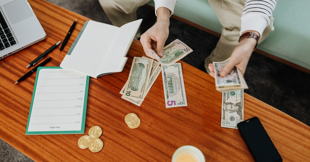 An overhead shot of someone counting money out on a table