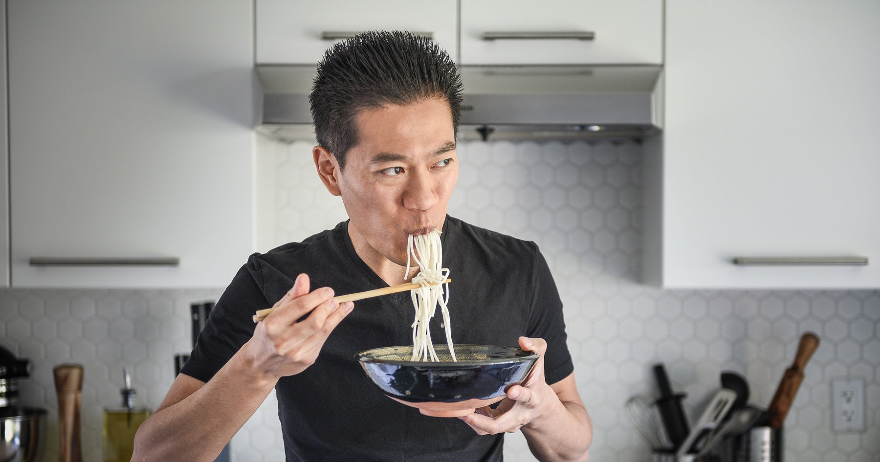 Portrait of Wil Yeung, YouTube chef and serial entrepreneur, eating a bowl of noodles