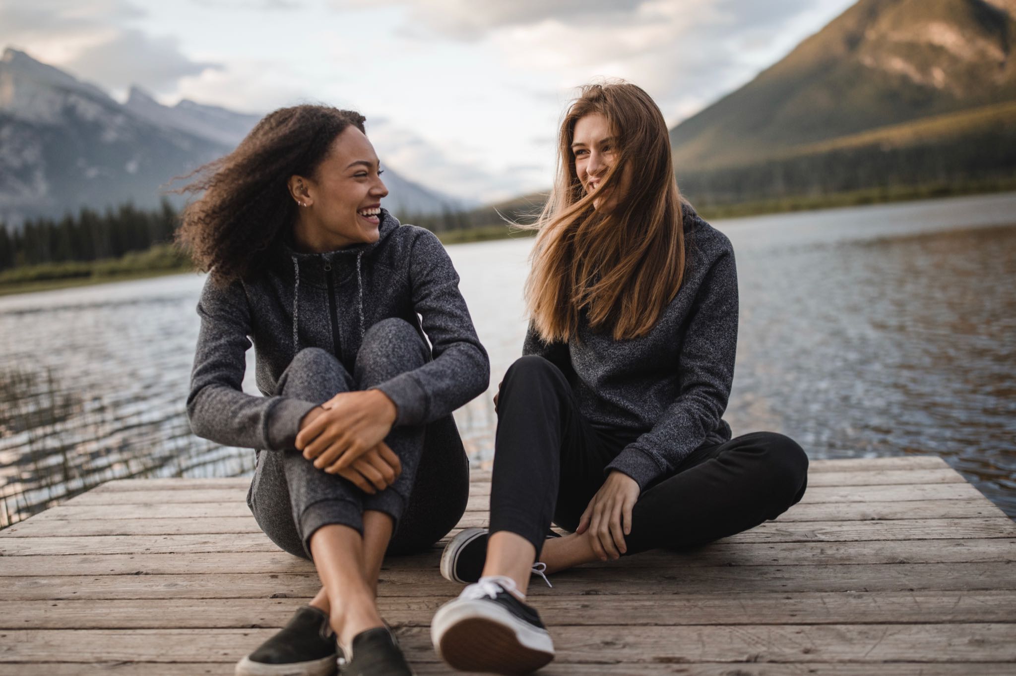 Clothing from Tentree worn by two models near a lake. 