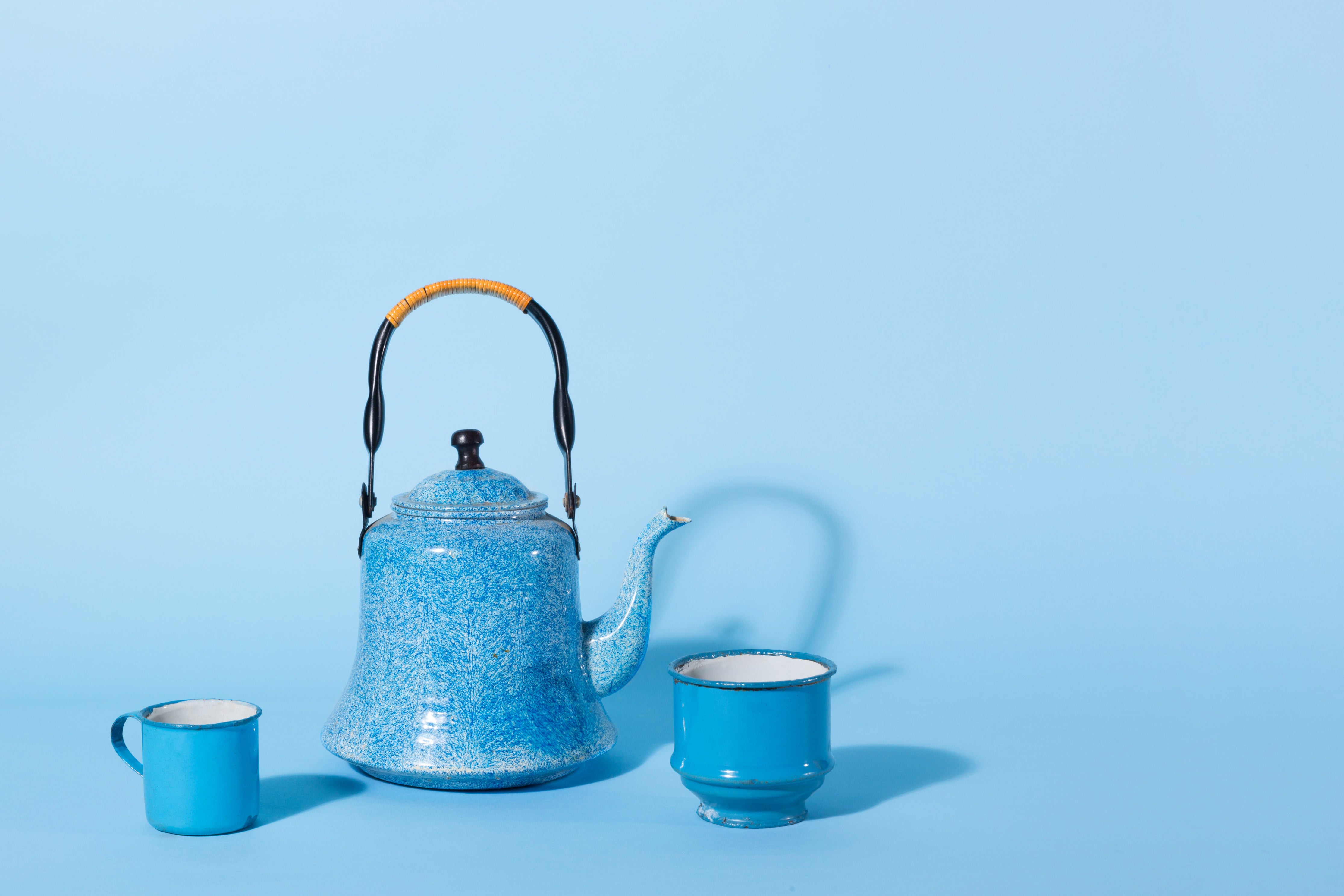 Product photo of a blue tea set against a solid blue background