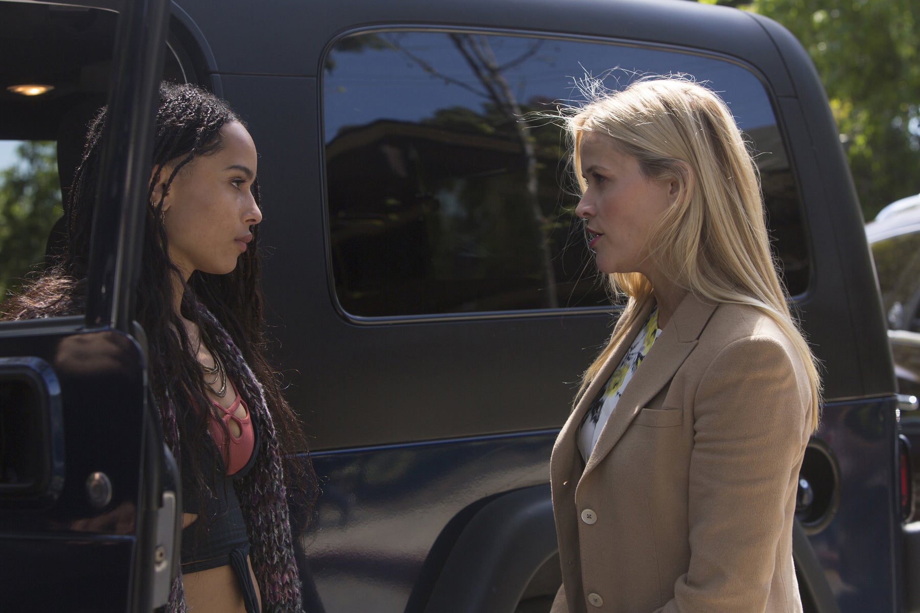 Bonnie and Madeline stand outside of Bonnie’s Jeep, talking.