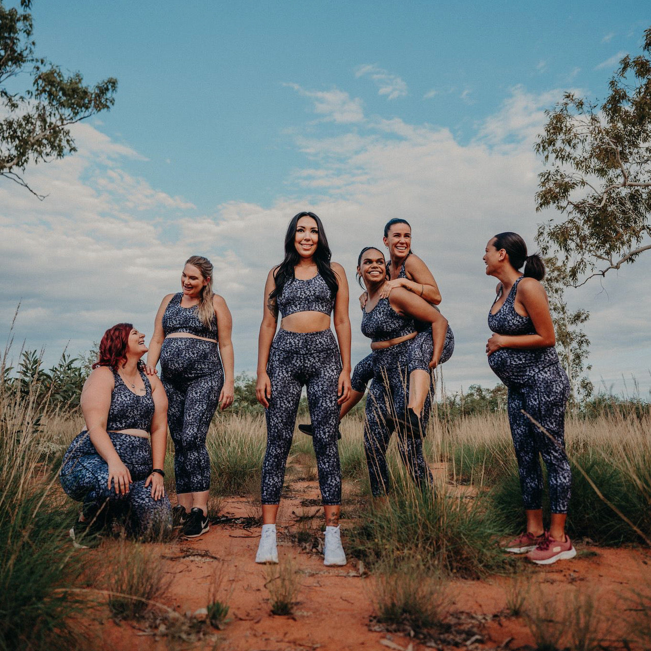 A group six women in various life stages wearing the same workout outfit by Active Truth in a dessert setting.