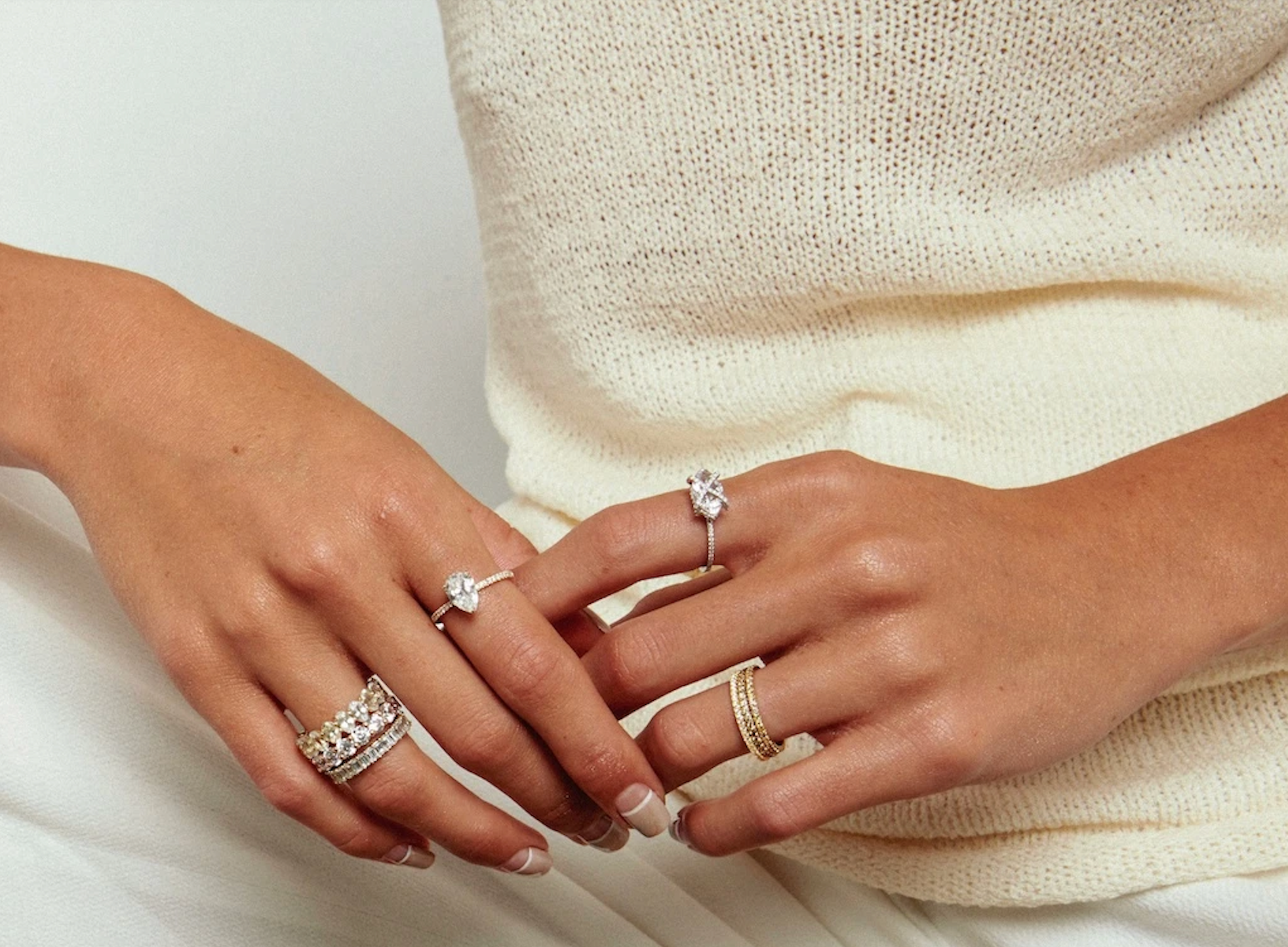 A close up of a woman wearing several Aprés Jewelry rings on both hands.