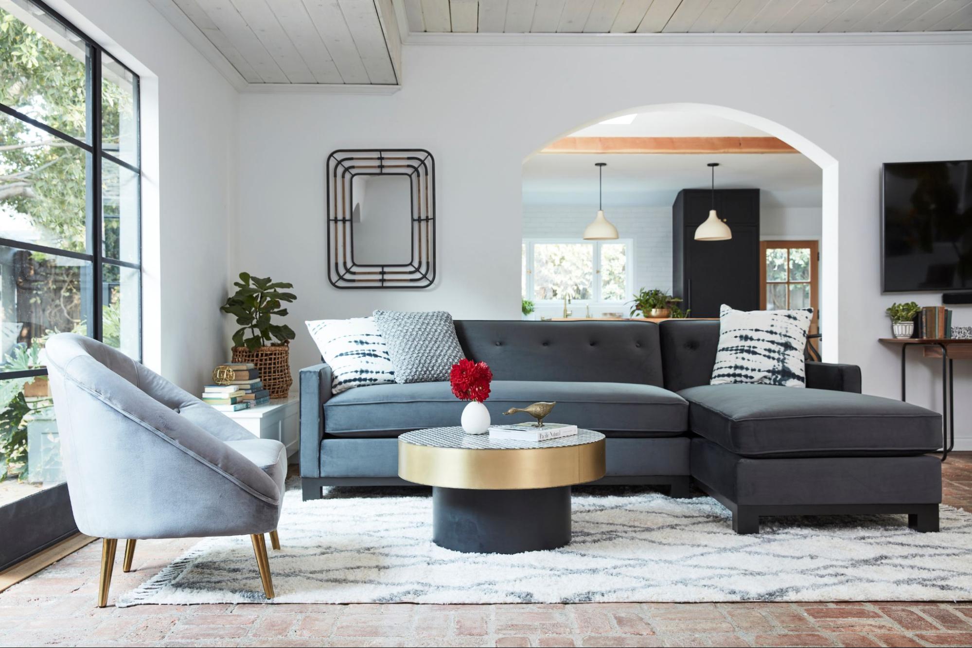 A dark grey sofa with a grey loveseat backdropped by a living room setting 