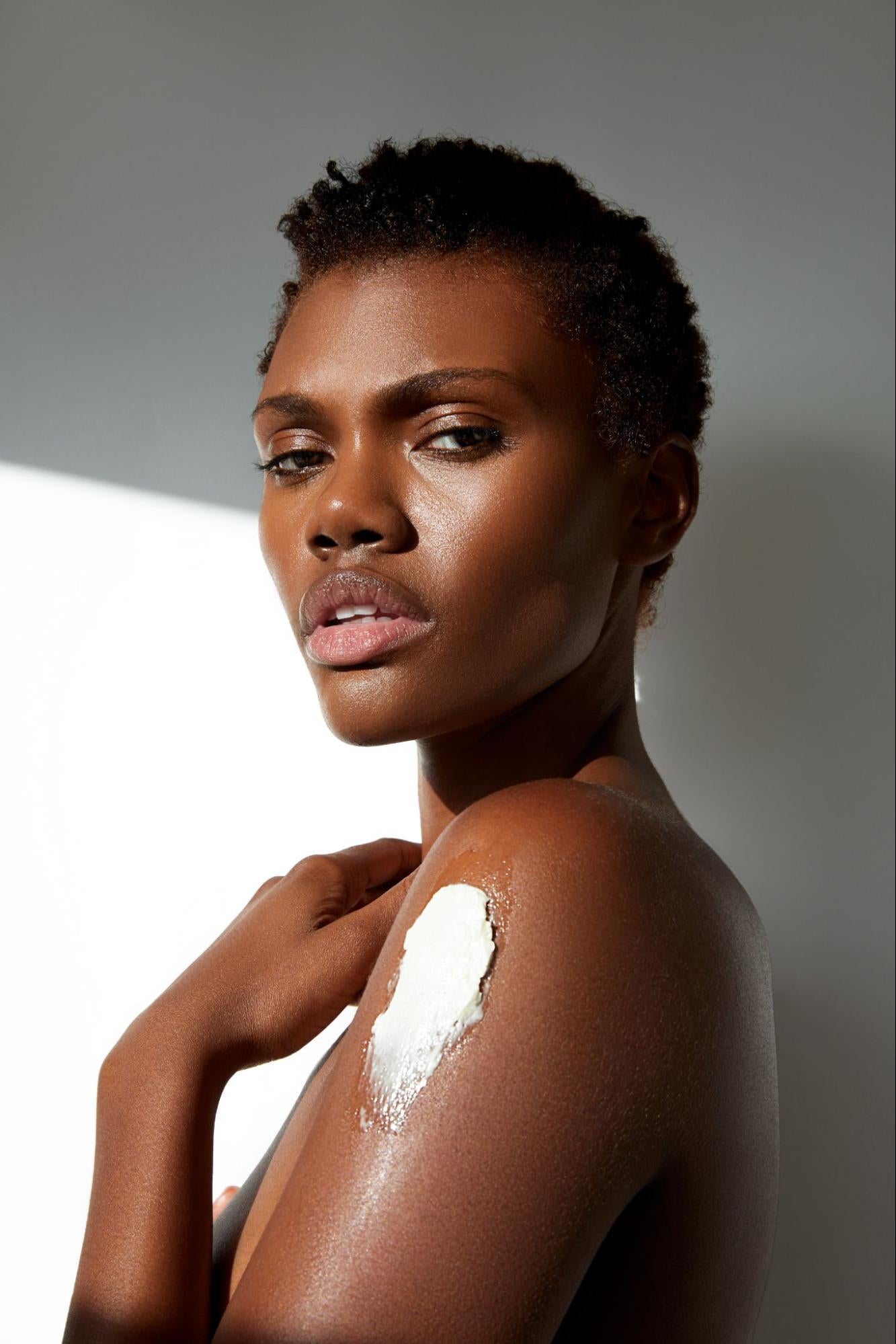 A model with some skin cream on her arm.