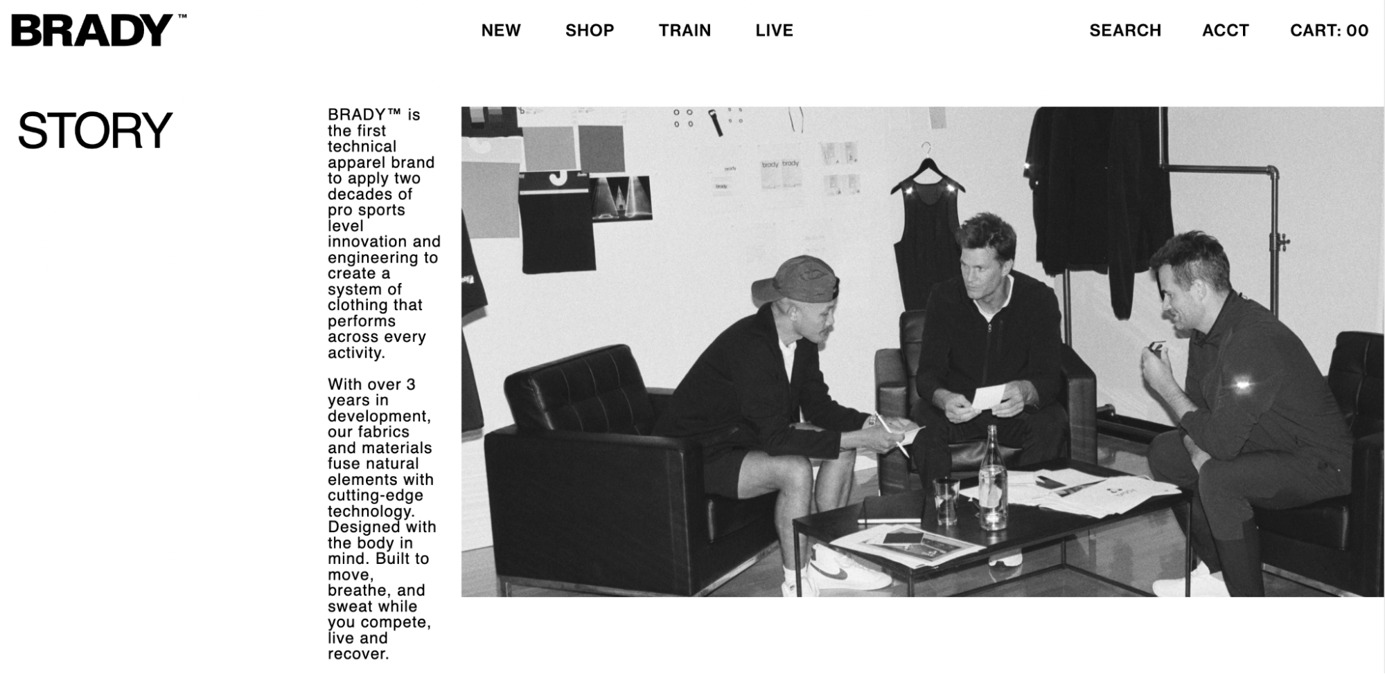 Screenshot of BRADY About Us page which includes a large black and white image of the founders sitting on chairs discussing business.