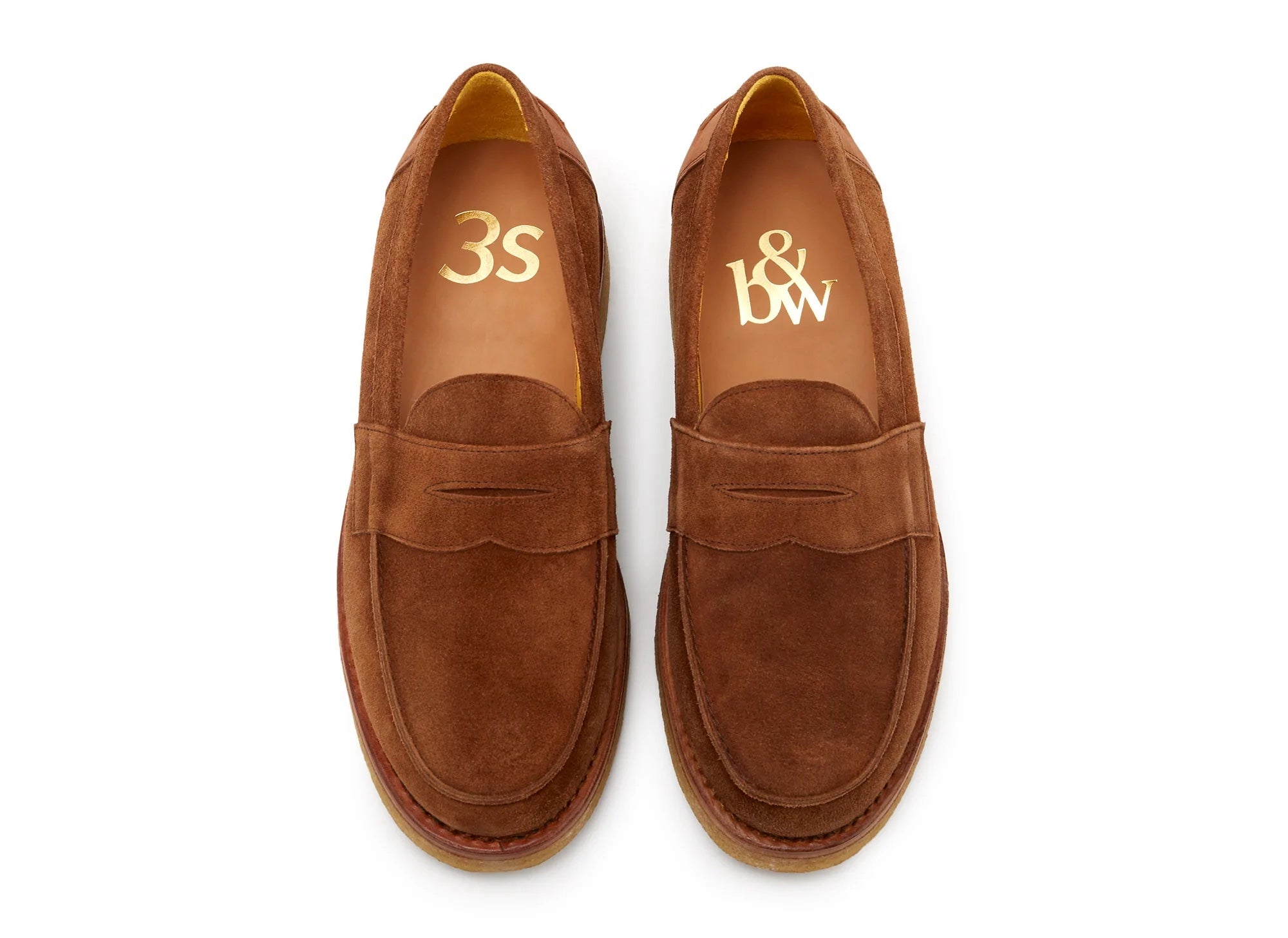 A pair of brown suede loafers on a white surface