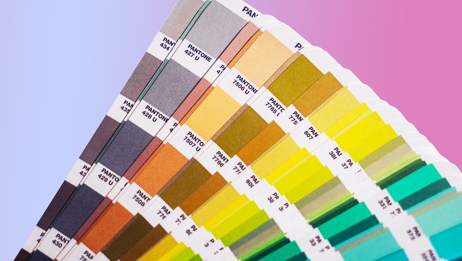 An array of Pantone color swatches against an ombre background