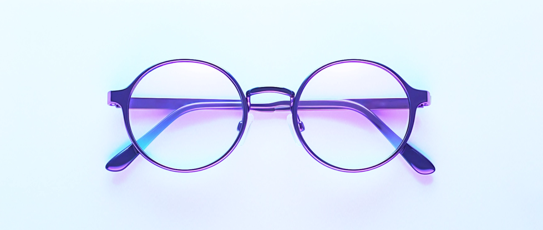 A pair of glasses folded on a light blue background.