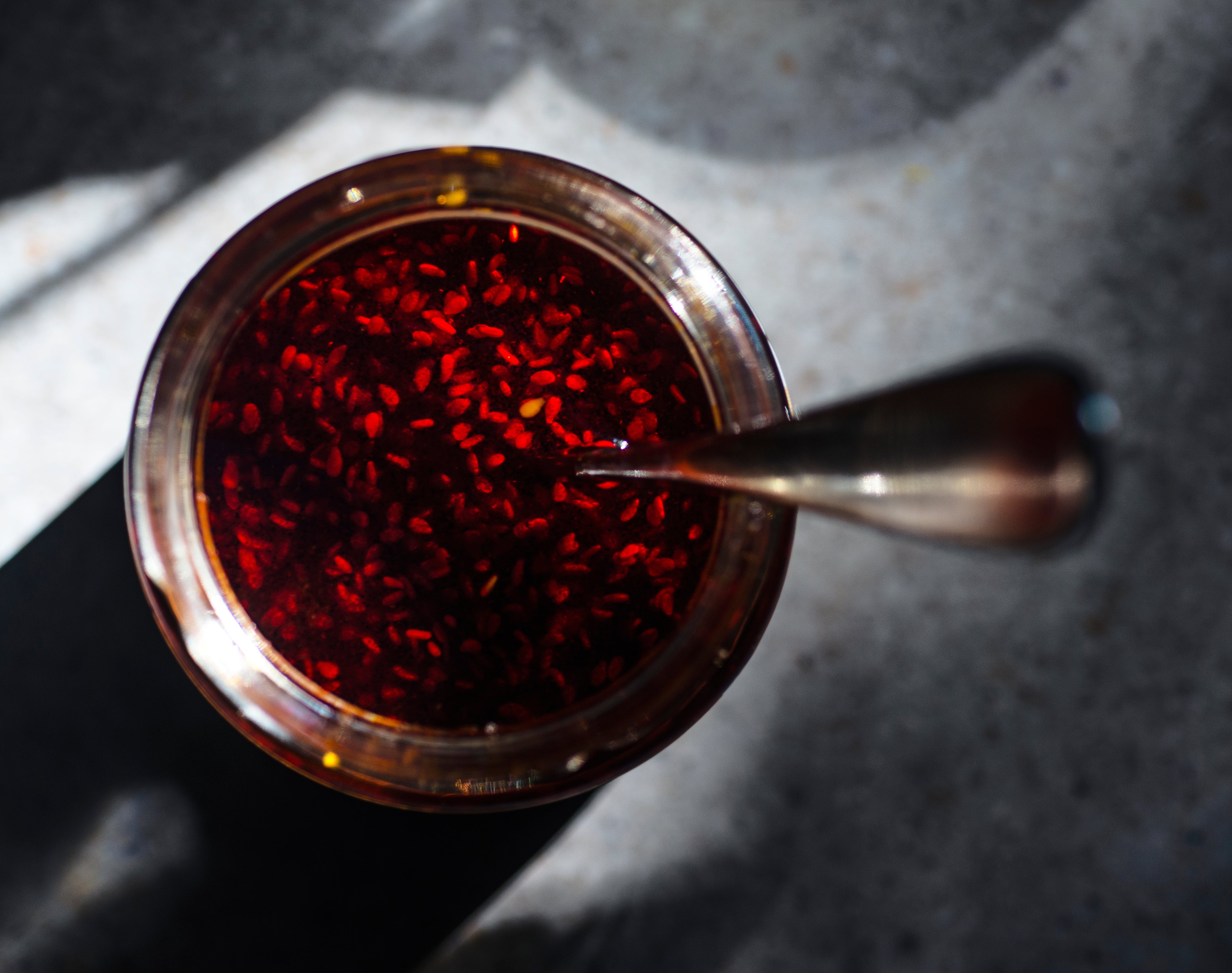 Birds eye view of a jar of spicy oil with a spoon