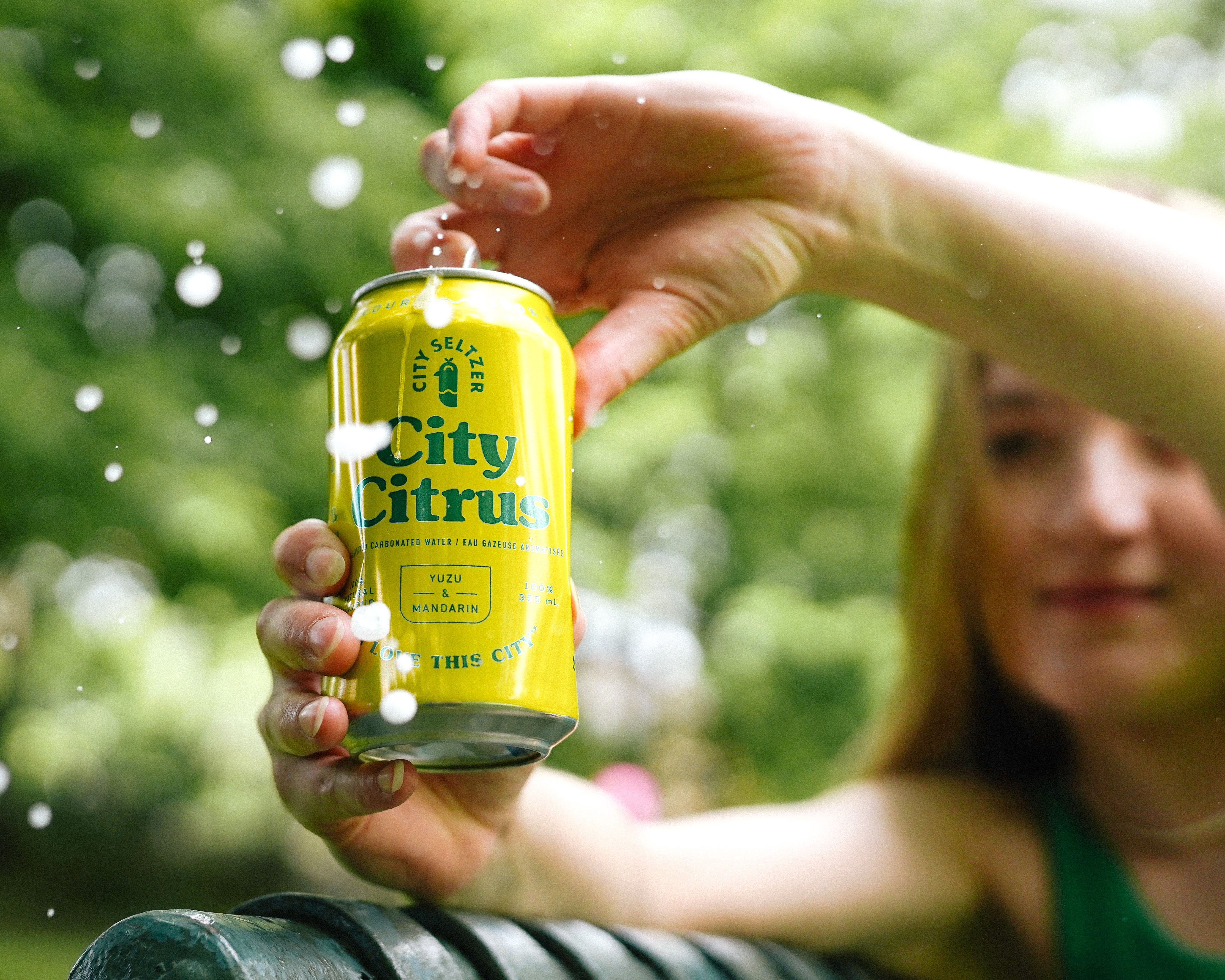 A woman cracking open a City Seltzer can