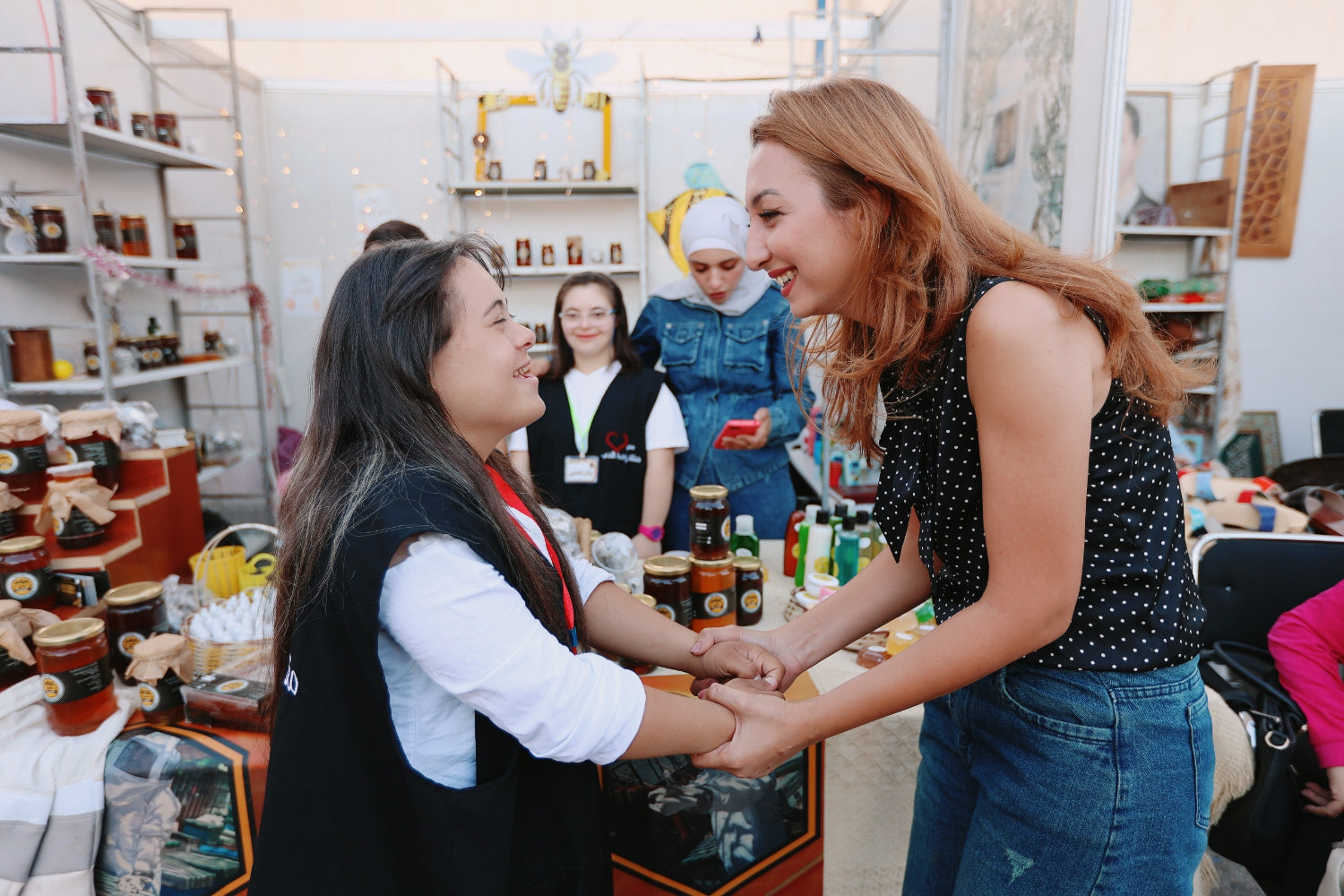 A woman greets another woman in a shop.